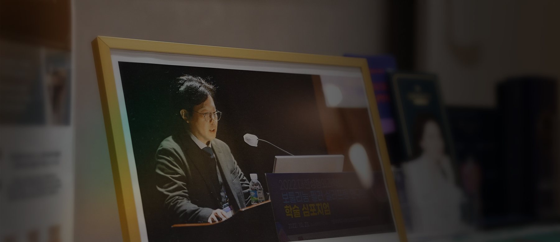 학술 심포지엄에서 강연하는 김대현 대표원장 사진 액자